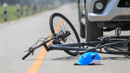 ein Fahrrad liegt vor einem Auto auf der Straße